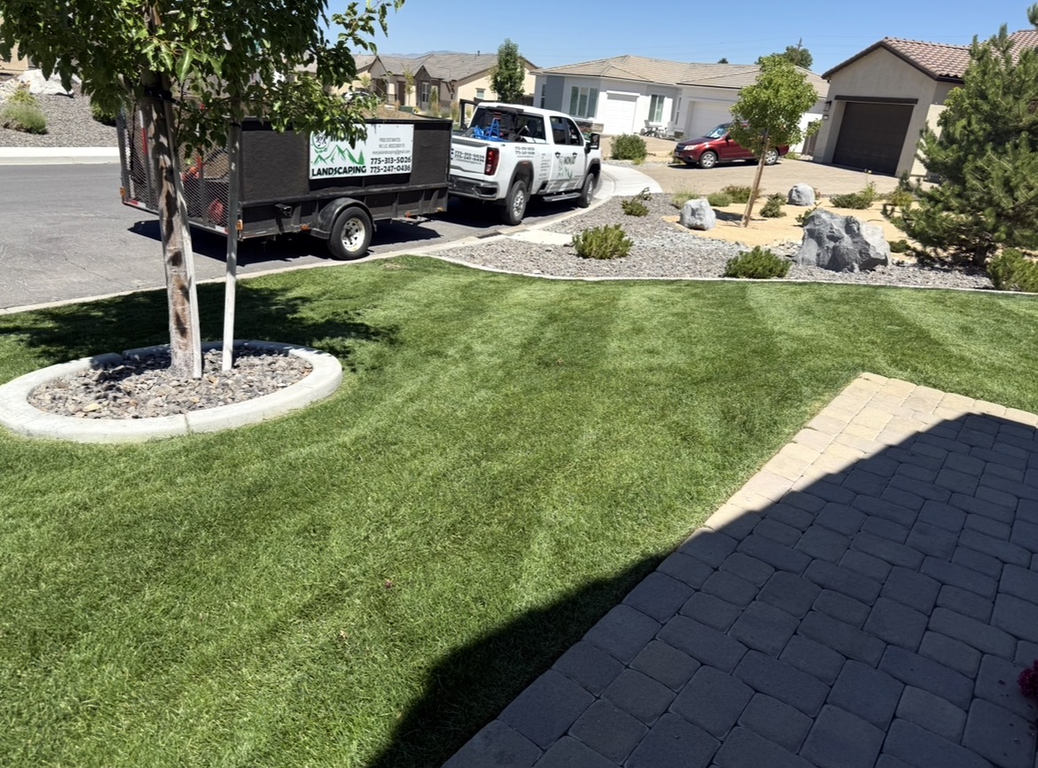 Manicured front lawn with paver edging and Monjas Landscaping truck