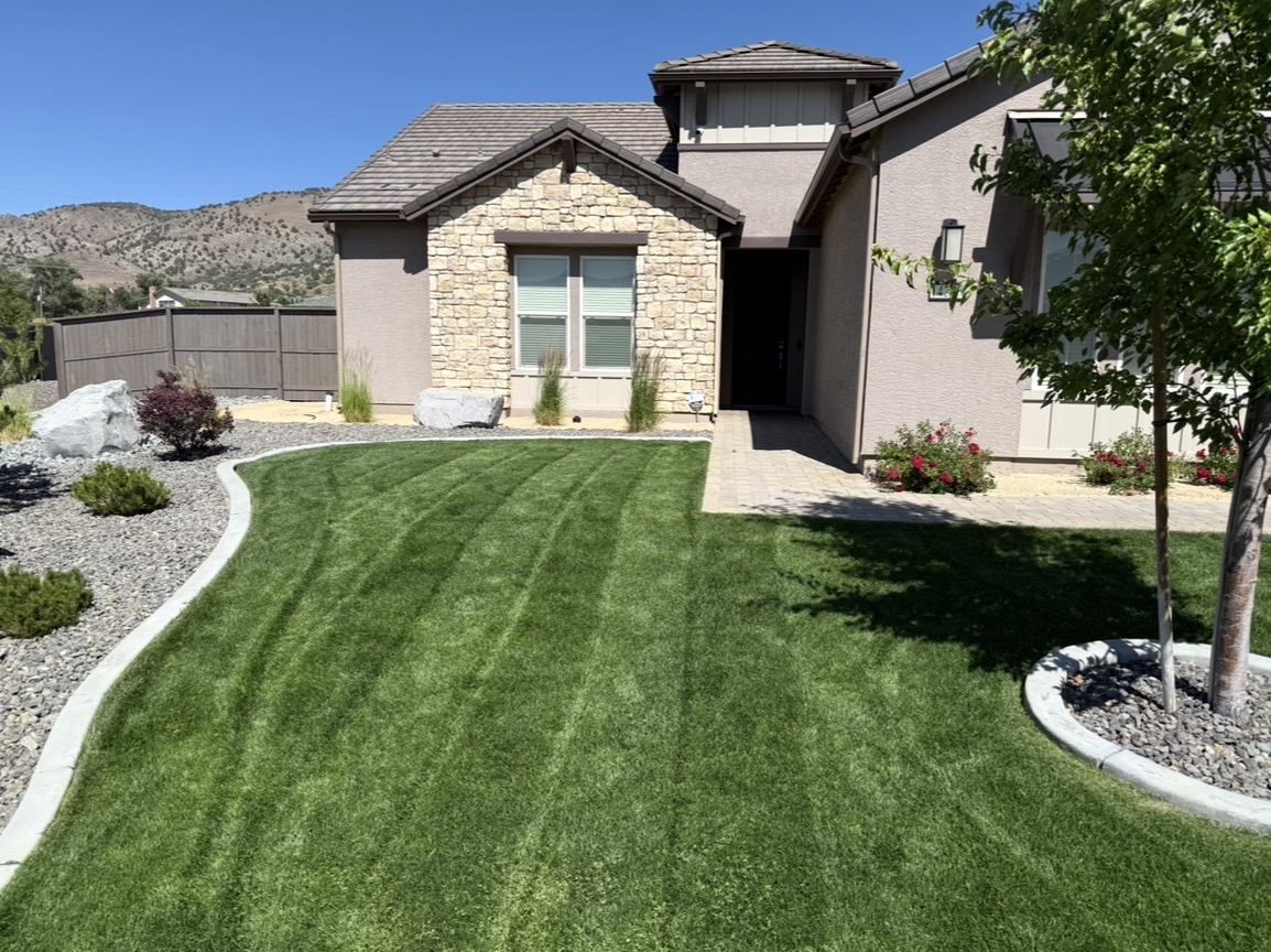 Freshly mowed lawn with striping at stone-front Reno home